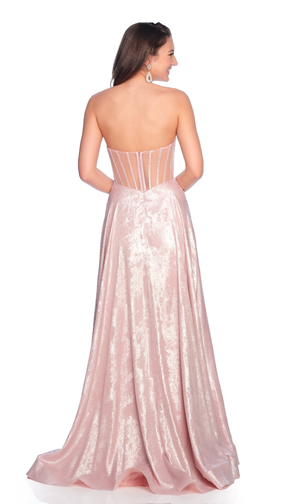 Woman in the Dave & Johnny 12182 light pink prom dress, a strapless floor-length gown with shimmery fabric and sheer corset back panels, standing against a white background.